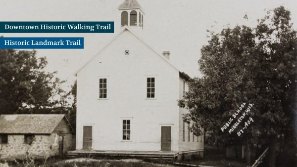 Vintage photo of a two-story public school building with a belfry and nearby stone outbuilding. Trees surround the structures. Text reads "Public School, Norborne 1874-1907.