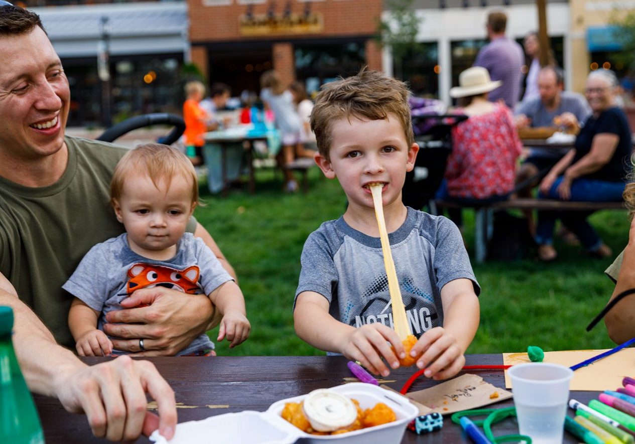 a man sitting at a table with three children.