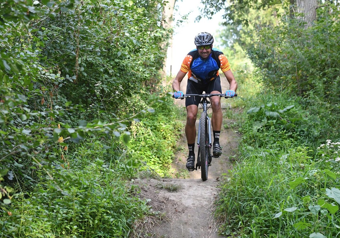 a man riding a bike down a dirt road